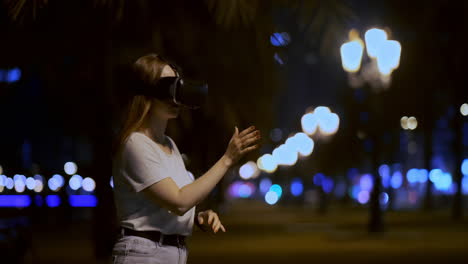 Young-girl-Simulated-virtual-reality-work-in-glasses-in-modern-big-city-at-night-on-my-lanterns-and-beautiful-bokeh-of-passing-cars-and-buildings